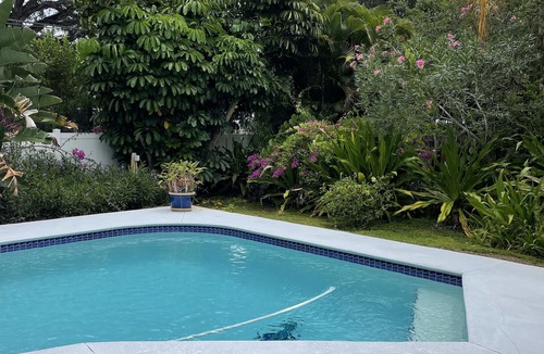 Central Beach House | A tropical retro bungalow secluded area with terrazzo flooring & heated pool.
